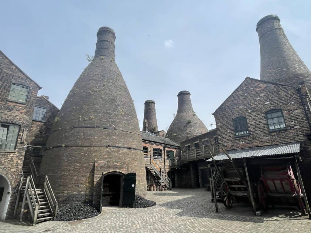 large brick bottle kilns surrounded by old factory buildings and a few deposits of coal