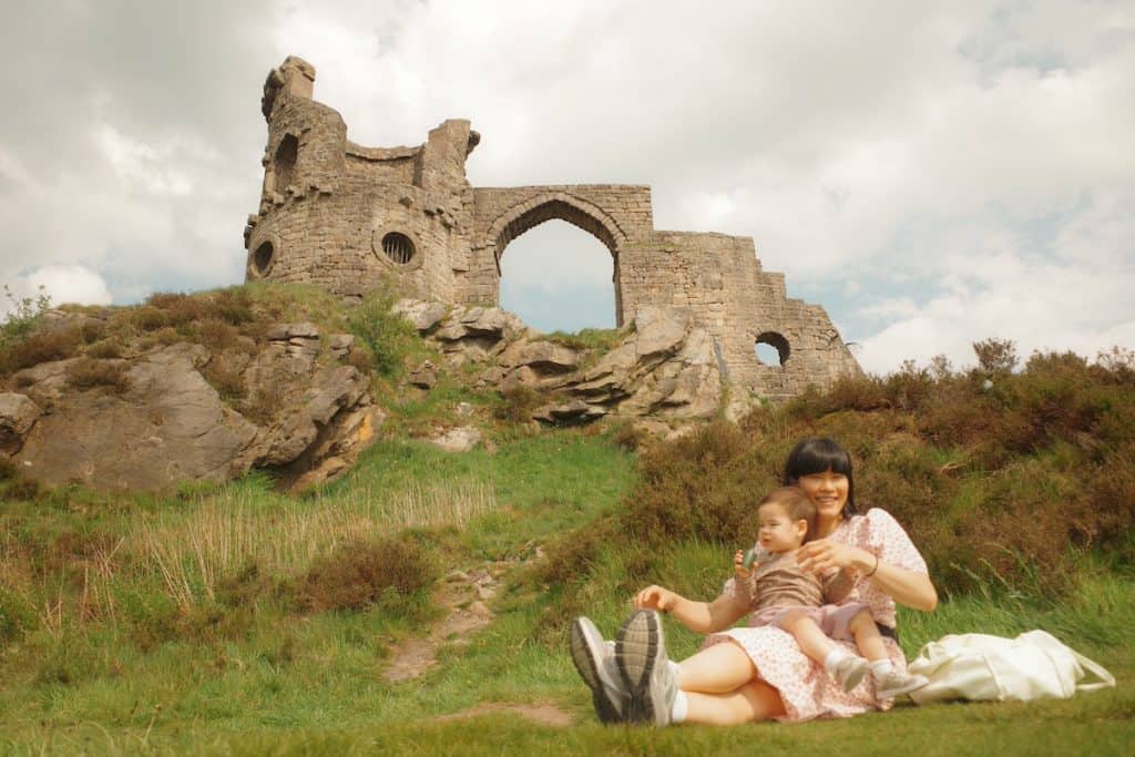 young woman and toddler sitting in front of mow cop castle