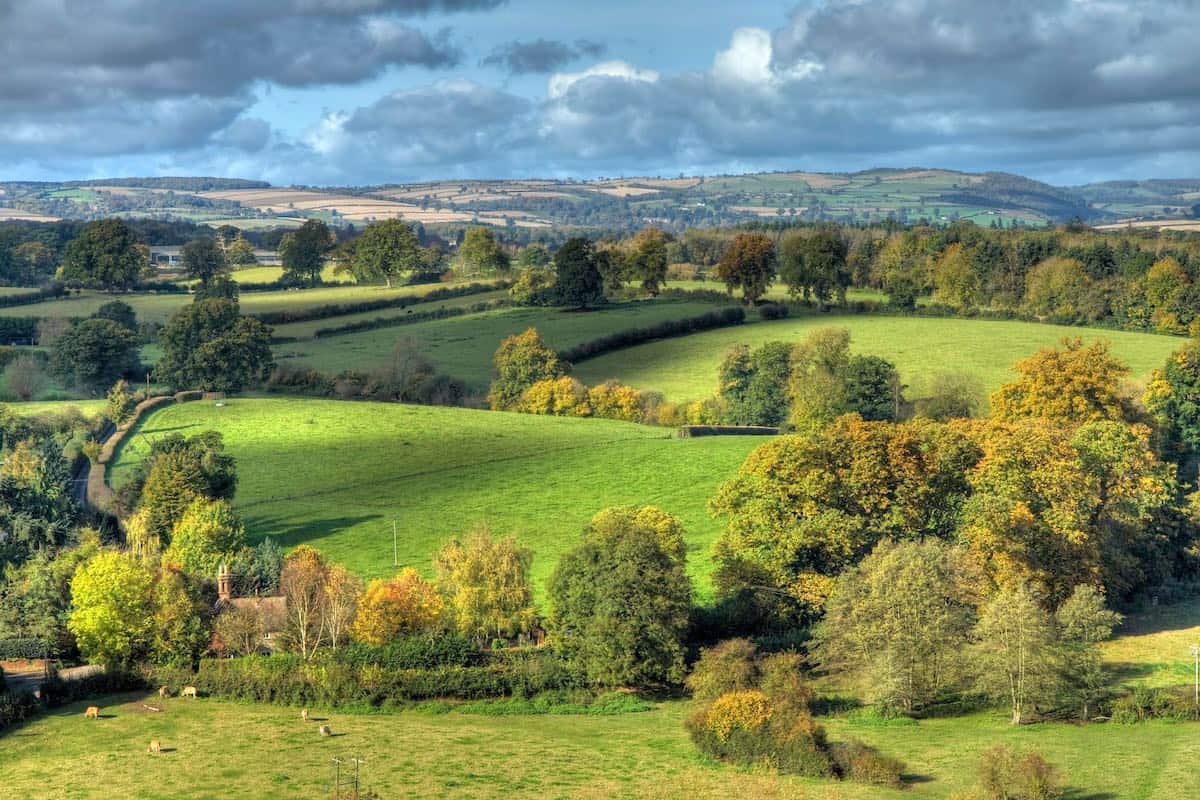 views across the green countryside with cloudy skies in shropshire