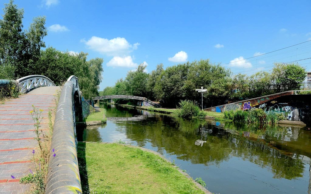 a canal splitting threeways with low bridges over them and trees surrounding the area