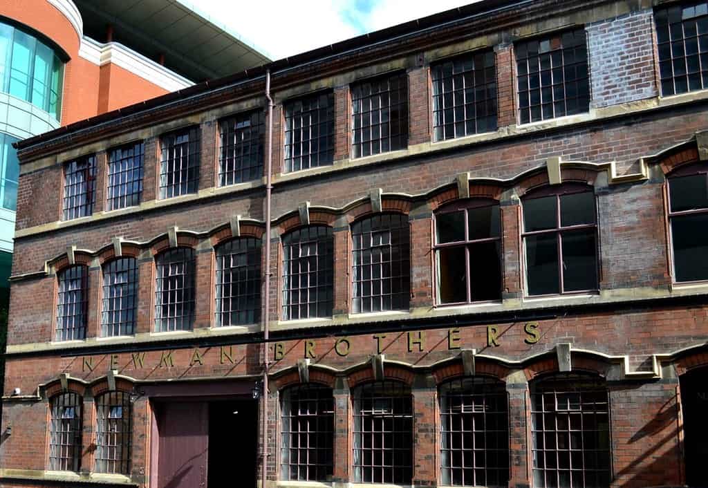 front view of the 19th century newman brothers coffin works factory museum, with large double door entrance and numerous tiled windows, and the newman brothers sign across the front of the building above the first level