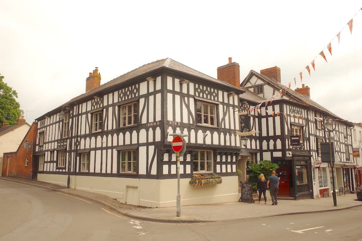 black and white timber-framed tudor building on the corner of a street with black pub exterior and sign saying the black bear