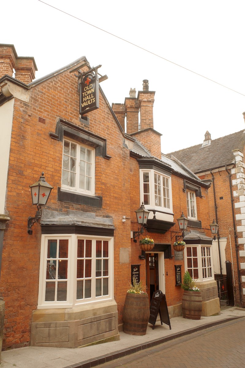 old brick georgian pub building down an alleyway with sign saying old town hall vaults