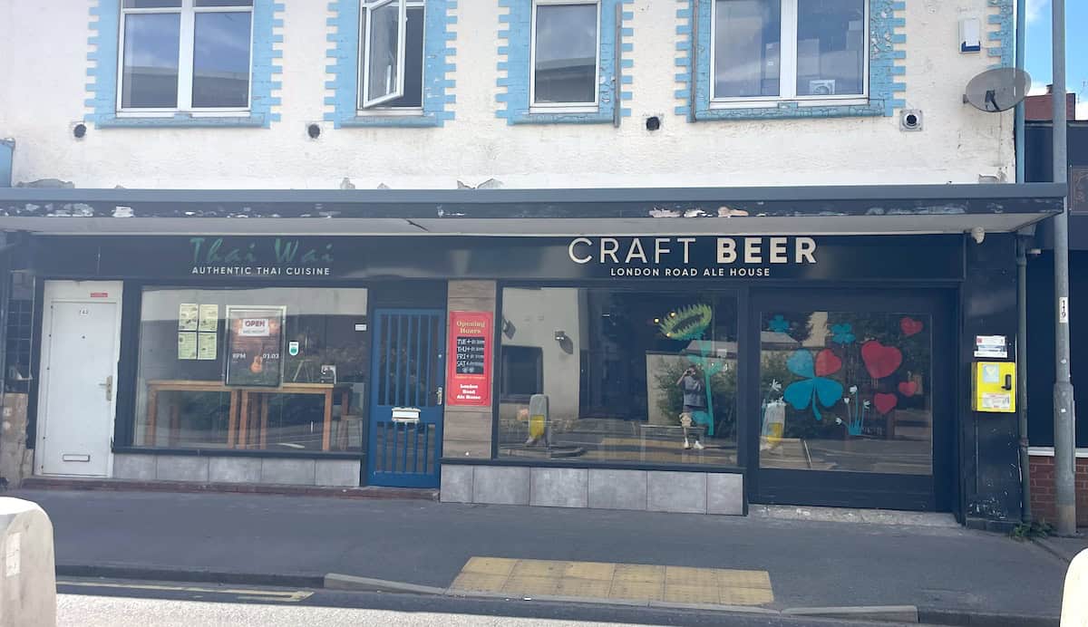 A street-level view of two adjacent businesses - a Thai restaurant with "Authentic Thai Cuisine" signage on the left, and the "Craft Beer London Road Ale House" on the right, both housed in a building with blue-trimmed windows above.